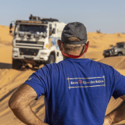 Photo de dos de Jacky Lechleiter avec le camion d'assistance en fond