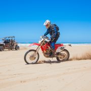 Moto rouge qui roule a côté de la mer