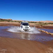 4x4 qui roule dans un petit lac au milieu du désert du maroc
