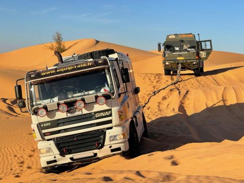 Camion d'assistance GINAF en premier plan avec un véhicule le suivant derrière