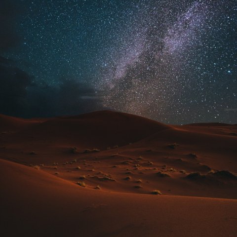 Photo prise dans le désert durant la nuit avec les étoiles dans le ciel