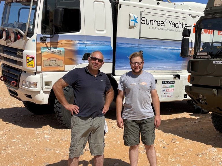 Photo de Jacky et Tom durant un raid en Tunisie avec en fond le véhicule d'assistance