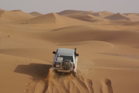 Photo d'un 4x4 prise de l'arrière dans le désert